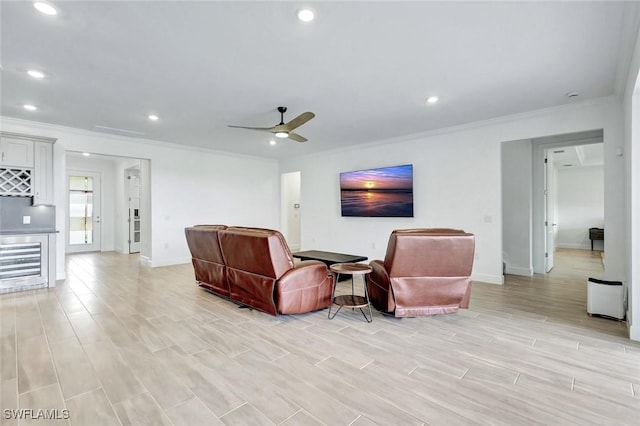 living area featuring light wood-type flooring, recessed lighting, ornamental molding, and a ceiling fan
