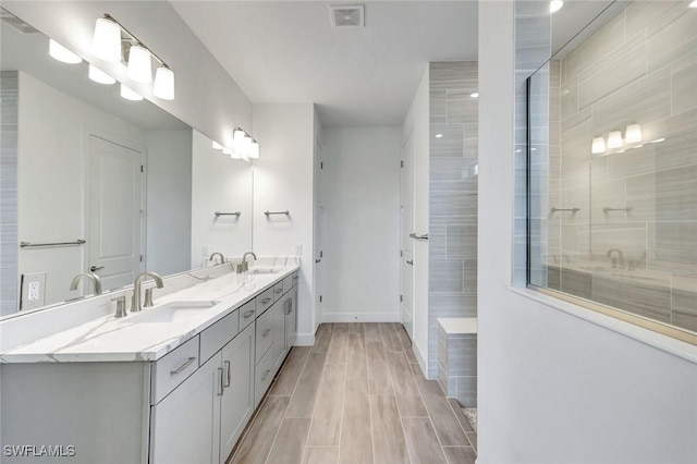 full bathroom featuring baseboards, visible vents, a sink, and double vanity