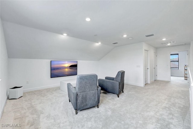 home theater room with baseboards, lofted ceiling, light colored carpet, and visible vents