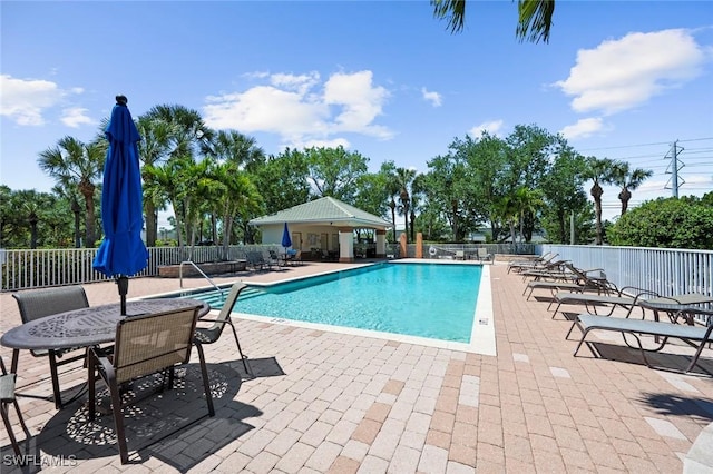 pool featuring fence and a patio area