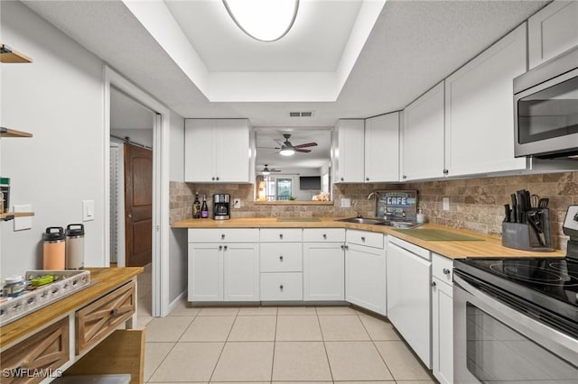 kitchen with visible vents, a sink, a ceiling fan, appliances with stainless steel finishes, and light tile patterned floors