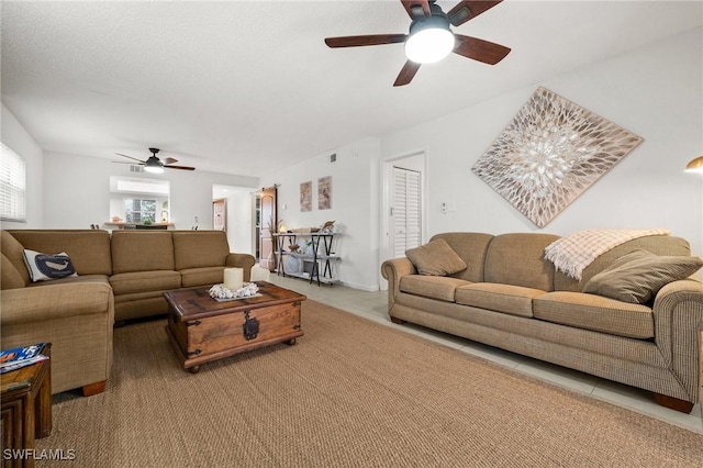 living area featuring ceiling fan and tile patterned flooring