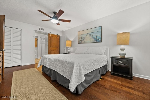bedroom with baseboards, visible vents, dark wood finished floors, and ensuite bath