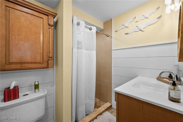 bathroom featuring toilet, a shower stall, and vanity