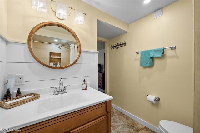 full bath featuring baseboards, vanity, and toilet