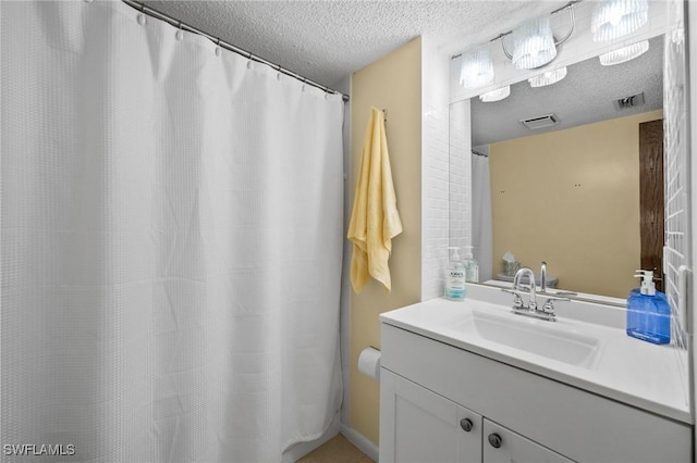 bathroom featuring vanity, a textured ceiling, and visible vents