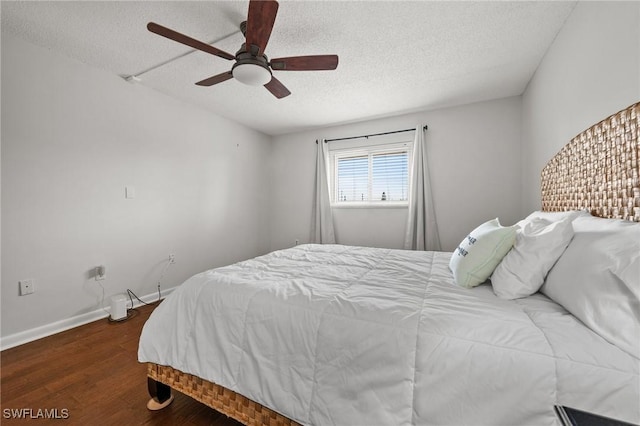 bedroom featuring baseboards, ceiling fan, a textured ceiling, and wood finished floors