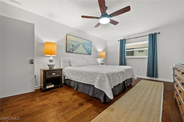 bedroom featuring a ceiling fan, a textured ceiling, and dark wood-style flooring