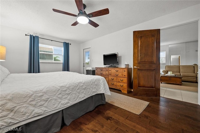 bedroom with a ceiling fan, a textured ceiling, and hardwood / wood-style floors
