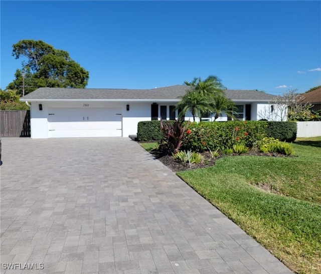 160 Coral Vine Dr, Naples, FL 34110 - single story home featuring stucco siding, a garage, fence, and decorative driveway