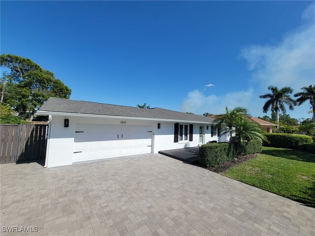 160 Coral Vine Dr, Naples, FL 34110 - ranch-style home featuring fence, stucco siding, an attached garage, and decorative driveway