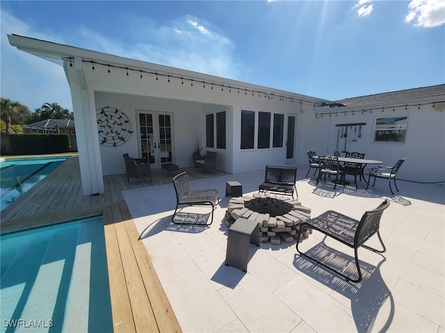 160 Coral Vine Dr, Naples, FL 34110 - back of property with an outdoor fire pit, stucco siding, french doors, and a fenced in pool