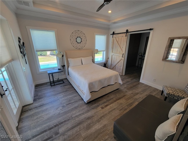 160 Coral Vine Dr, Naples, FL 34110 - bedroom with a tray ceiling, a barn door, wood finished floors, baseboards, and visible vents
