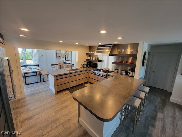 160 Coral Vine Dr, Naples, FL 34110 - kitchen with stainless steel gas stovetop, a peninsula, wood finished floors, recessed lighting, and a sink