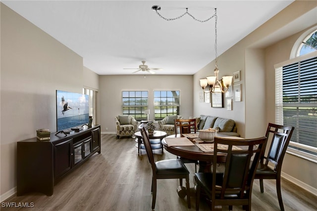 dining area with wood finished floors, baseboards, a chandelier, and ceiling fan