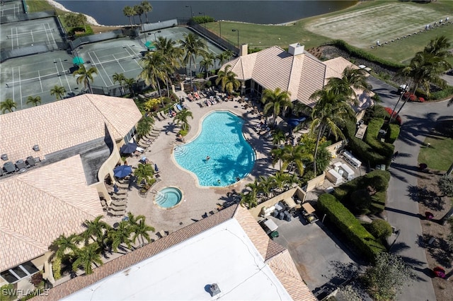 drone / aerial view of a pool area and a large body of water
