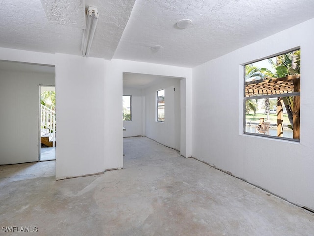 4738 Jackfish St, Bonita Springs, FL 34134 - spare room with unfinished concrete floors and a textured ceiling