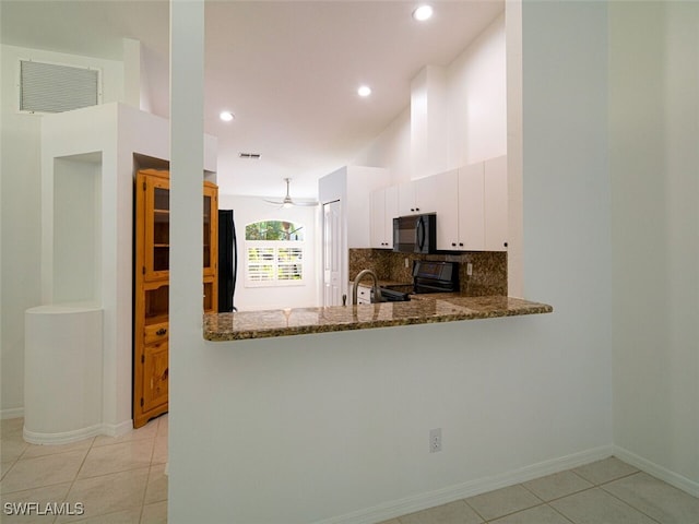 kitchen featuring dark stone counters, black appliances, light tile patterned flooring, backsplash, and visible vents