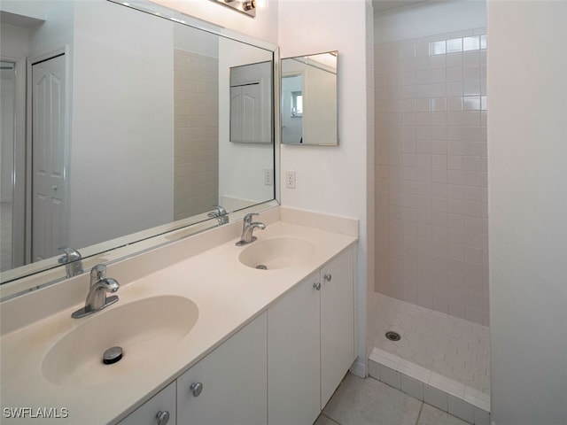 bathroom featuring tile patterned floors, double vanity, a sink, and a walk in shower