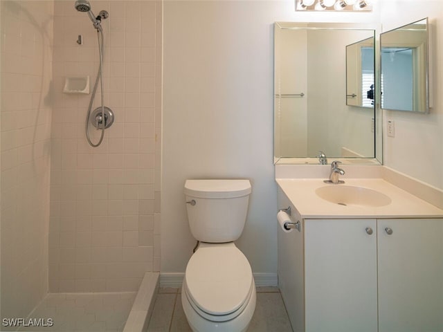 full bathroom featuring a tile shower, vanity, and toilet