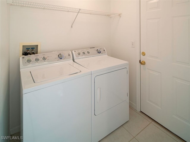 laundry area featuring separate washer and dryer, laundry area, and light tile patterned flooring