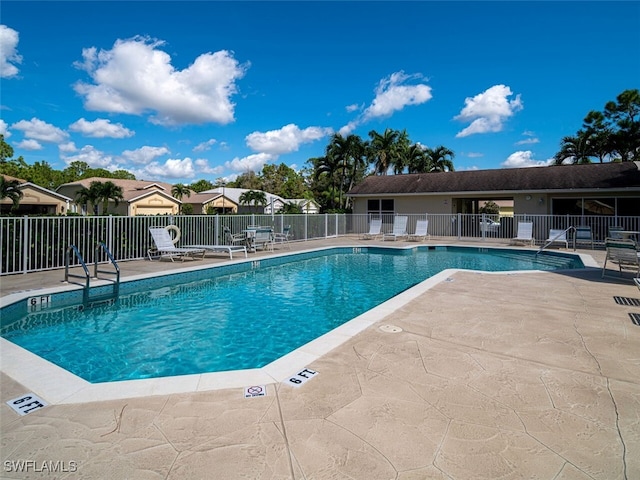 community pool featuring fence and a patio