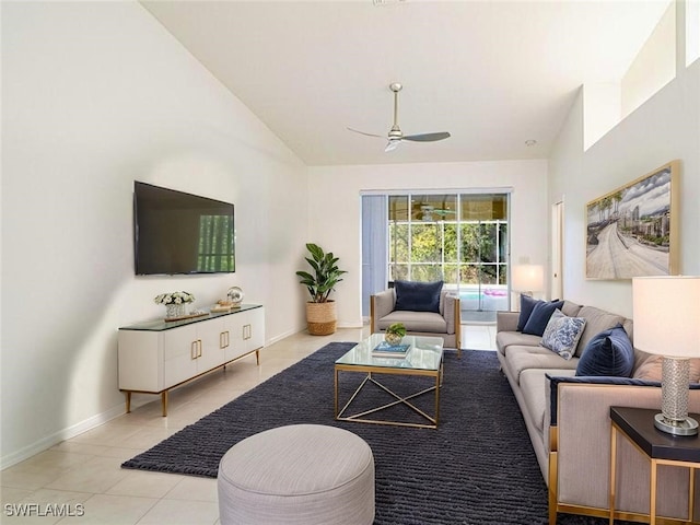 living room featuring vaulted ceiling, a ceiling fan, baseboards, and light tile patterned floors
