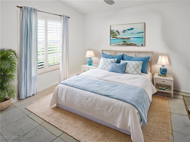 bedroom featuring lofted ceiling, multiple windows, and baseboards