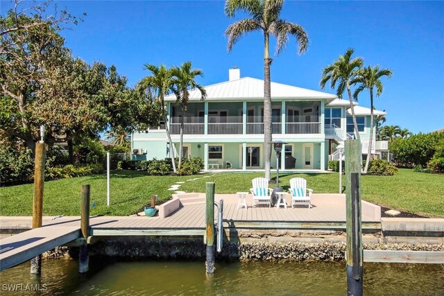 view of dock featuring a lawn and a water view