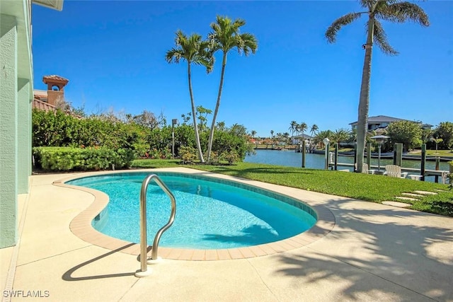 outdoor pool with a lawn, a water view, and a dock