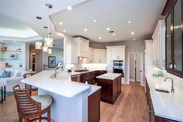 kitchen featuring dark brown cabinets, white cabinets, a sink, and stainless steel appliances