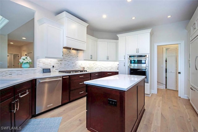 kitchen featuring light countertops, tasteful backsplash, white cabinets, and appliances with stainless steel finishes