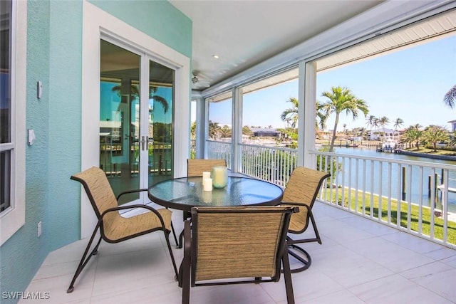 sunroom / solarium with a textured wall and a water view
