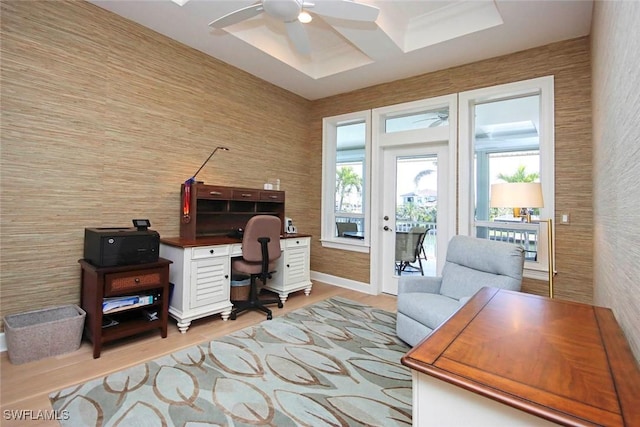 office space with baseboards, light wood-style floors, and a ceiling fan