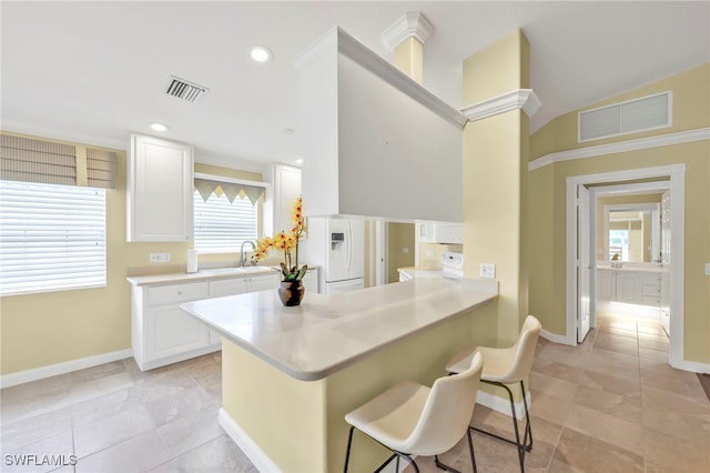 7547 Novara Ct, Naples, FL 34114 - kitchen with a breakfast bar, baseboards, light countertops, and visible vents