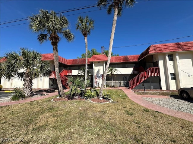 1376 Archer St Unit 6, Lehigh Acres, FL 33936 - view of front of house featuring a front yard, stucco siding, and stairs