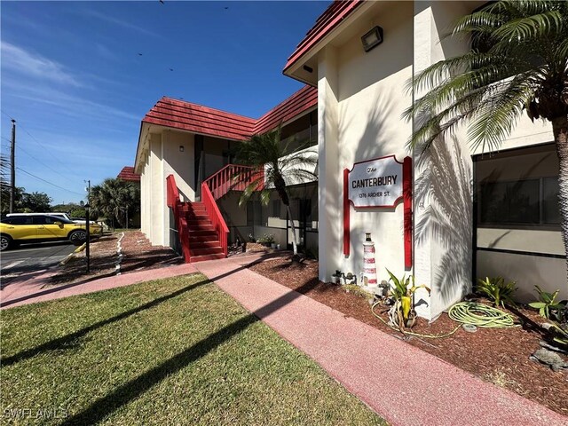 1376 Archer St Unit 6, Lehigh Acres, FL 33936 - view of home's exterior featuring stairs, stucco siding, and a tiled roof