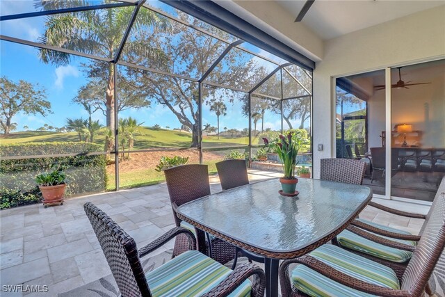 sunroom with ceiling fan and outdoor dining area
