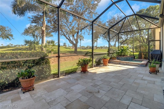 view of patio / terrace with an outdoor hot tub and glass enclosure