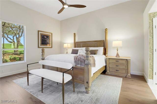 bedroom featuring light wood-type flooring, ceiling fan, baseboards, and multiple windows
