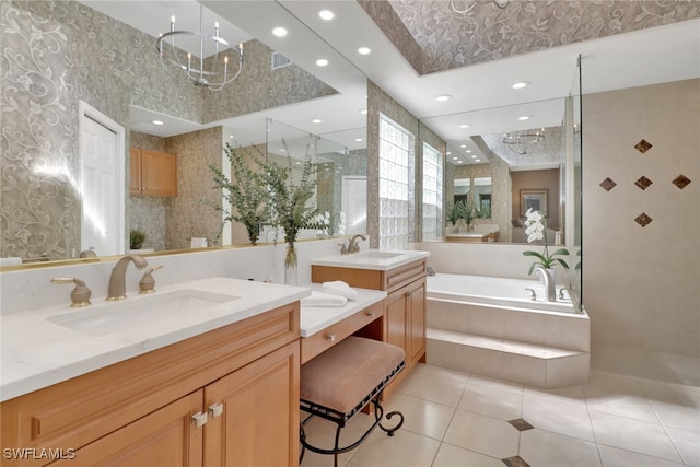 bathroom featuring tiled shower, a notable chandelier, a garden tub, and a sink