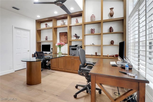 office space featuring built in shelves, recessed lighting, a ceiling fan, visible vents, and light wood finished floors