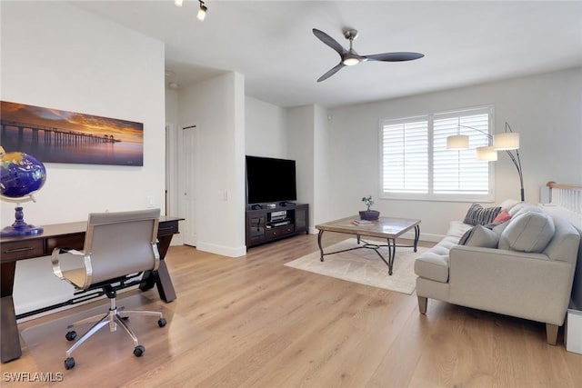 living area with light wood finished floors, baseboards, and ceiling fan
