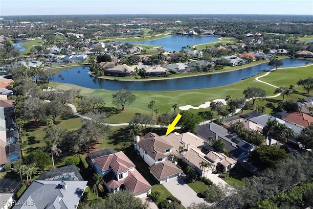 drone / aerial view with a water view, view of golf course, and a residential view