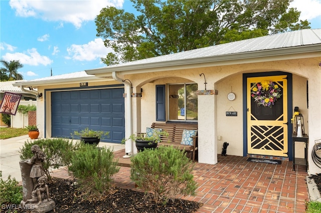 view of front of house featuring covered porch, driveway, stucco siding, and an attached garage