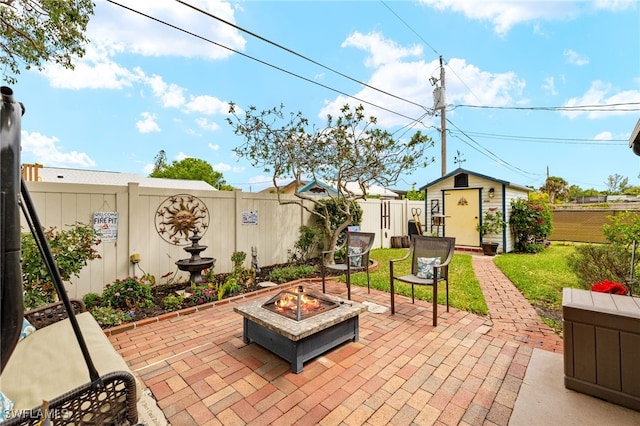 view of patio / terrace with an outdoor fire pit, a fenced backyard, and an outdoor structure