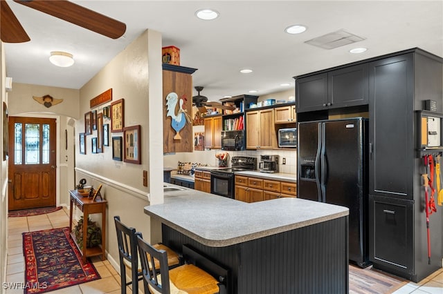kitchen featuring light tile patterned flooring, decorative backsplash, visible vents, ceiling fan, and black appliances