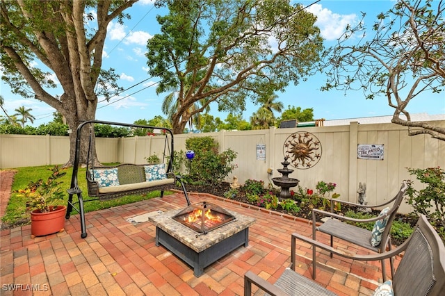 view of patio with a fenced backyard and a fire pit