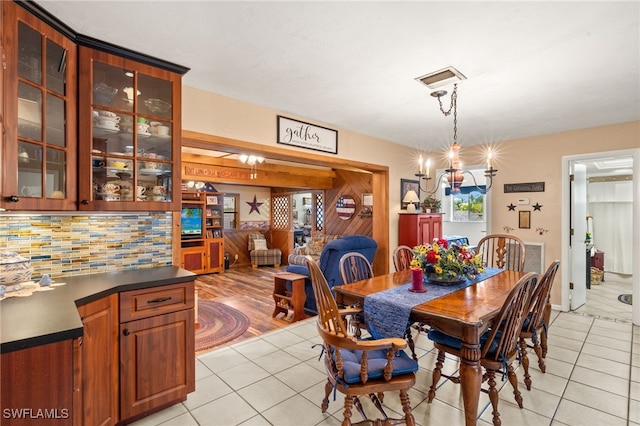 dining space featuring an inviting chandelier, light tile patterned floors, and visible vents