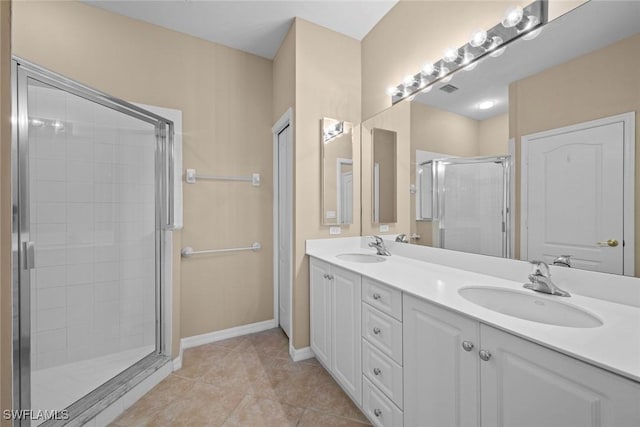 full bathroom featuring a stall shower, double vanity, tile patterned flooring, and a sink